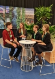 Auf der Abbildung sieht man die Teilnehmer der Jugenddelegation, die an einem Tisch sitzen und ich austauschen