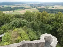 Zu sehen ist eine hügelige, ländlich geprägte Landschaft, in der sich Wälder mit landwirtschaftlichen Flächen abwechseln.