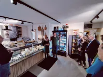 Mehrere Menschen stehen in einer Käserei im Allgäu.