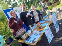 Beim Markt der Möglichkeiten stehen drei Personen hinter ihrem Gemeinschaftsstand von EUROPARC Federation, der MAB Jugend und EuroMAB Youth.