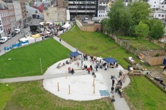 Blick von oben auf Spielplatz, Wiese und Gebäude