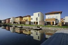 Wohnhäuser am Wasser mit Rasen