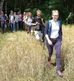 Eine Gruppe Menschen geht durch ein Feld.