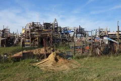 Spielplatz aus Holzelementen, davor Rasen. 