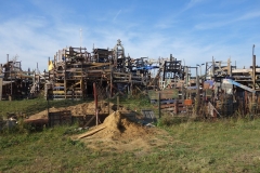 Spielplatz aus Holzelementen, davor Rasen. 