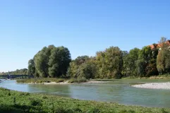 Fluss mit Wiese, Strand und Bäumen. 
