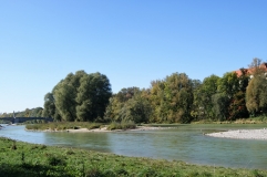 Fluss mit Wiese, Strand und Bäumen. 