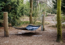 Eine Hängematte und ein Spielplatz im Wald.