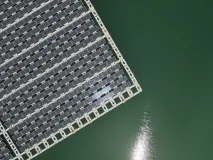 Das Foto zeigt eine Luftaufnahme (Blick aus der Vogelperspektive) einer schwimmenden PV-Anlage auf einem Baggersee in der Nähe von Karlsruhe.