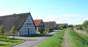 Das Foto zeigt Häuser der ortstypischen Architektur in Mittelnkirchen. Die Mauern bestehen aus Fachwerk und Backstein, während die Dächer zum großen Teil mit Reet gedeckt sind.