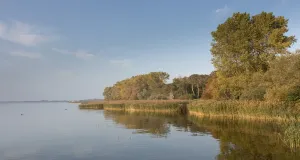 Der Kummerower See bei Gravelotte an einem sonnigen Herbsttag. Das Wasser erscheint ruhig.