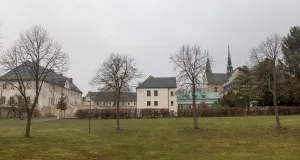 Im Vordergrund ist eine junge Baumgruppe zu sehen. Der Blick führt zur Klosteranlage Huysburg. Es herrscht eine winterliche Stimmung.