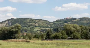 Das Bild zeigt markante Hänge des Saaletals. Auf einer Anhöhe ist die exponierte Leuchtenburg zu sehen.