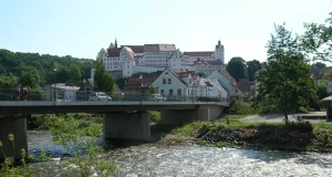 Das Foto zeigt die Mulde über die eine straßenbrücke führt sowie das Schloss Colditz über der gleichnamigen Stadt. Die Hänge des Muldetals sind mit Laubmischwäldern bestanden.