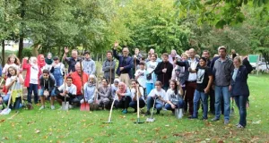 Menschengruppe mit Schaufeln auf einer Wiese