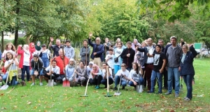 Menschengruppe mit Schaufeln auf einer Wiese