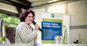 BfN-Präsidentin Sabine Riewenherm steht an einem Stehtisch und eröffnet das Gartengespräch
