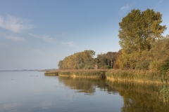 Der Kummerower See bei Gravelotte an einem sonnigen Herbsttag. Das Wasser erscheint ruhig.