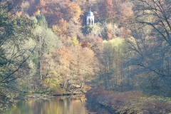 Zu sehen ist die ruhig fließende Wupper an einem sonnigen Herbsttag. Die angrenzenden Hänge sind bewaldet. Auf einer Anhöhe ragt der Diedrichstempel hervor.