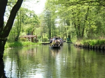 Das Foto zeigt die Hauptspree bei dem Spreewaldort Lehde. Der lichte Erlenbruchwald reicht bis an die Ufer der Spree. Die Spree wird von zwei typischen Spreewaldkähnen mit Touristenbefahren.