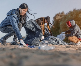 Personen sammeln Müll am Strand