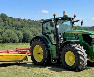 Traktor mit Mähwerk auf einer Wiese