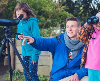 Kinder beobachten Vögel durch ein Fernglas