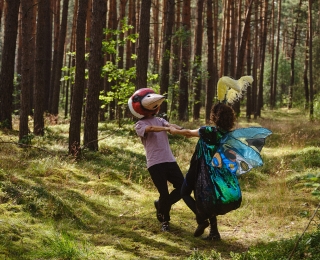 Zwei verkleidete Personen tanzen im Wald