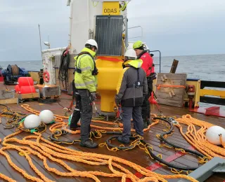 Menschen vor der Datentonne auf dem Schiff