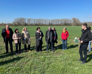 Frau Präsidentin Sabine Riewenherm steht mit mehreren Personen auf einer grünen Wiese