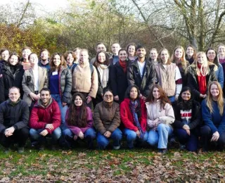 Gruppenfoto der Teilnehmenden auf einer Wiese mit Herbstlaub