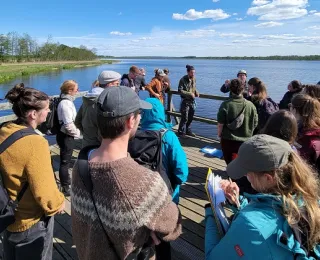 angehenden Moorspezialist*innen stehen auf einem Steg am Wasser