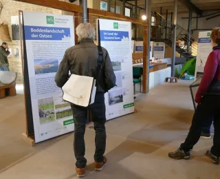 Besucher vor einer Ausstellungstafel